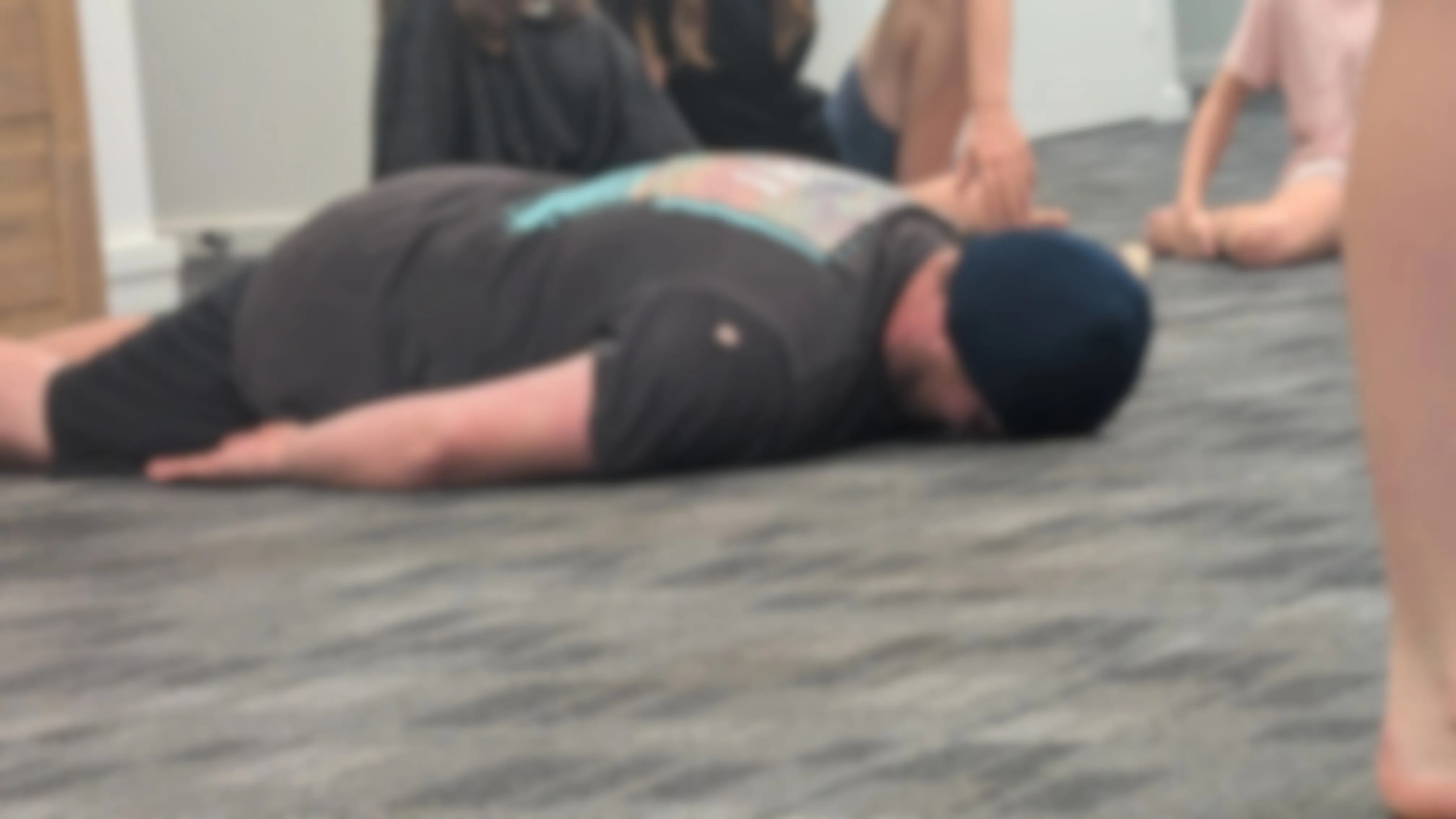 A blurred photo of a person lying face-down on the ground.