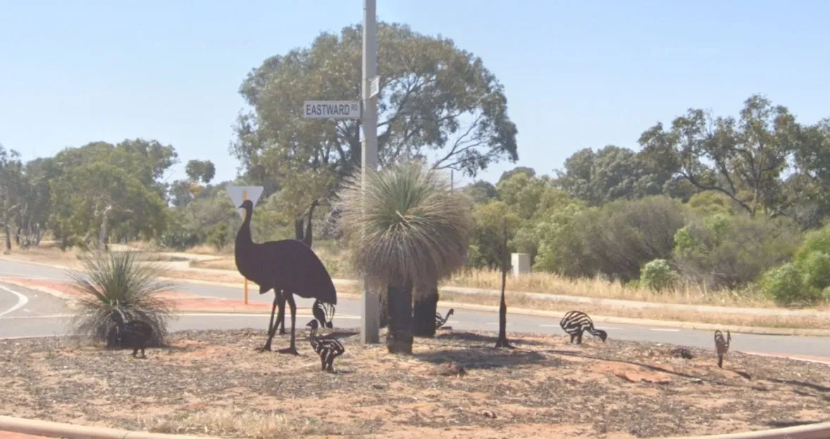 A photo of metalic emus on a roundabout